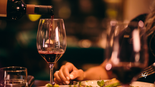 Close-up_of_sommelier_serving_red_wine_at_fine_dining_restaurant