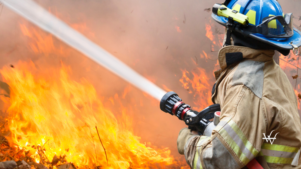 Firefighter Hosing a Wildfire