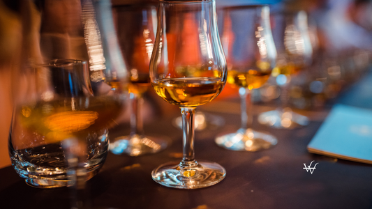 Glasses_with_brandy_stand_in_a_row._Blurred_background_warm_tinted