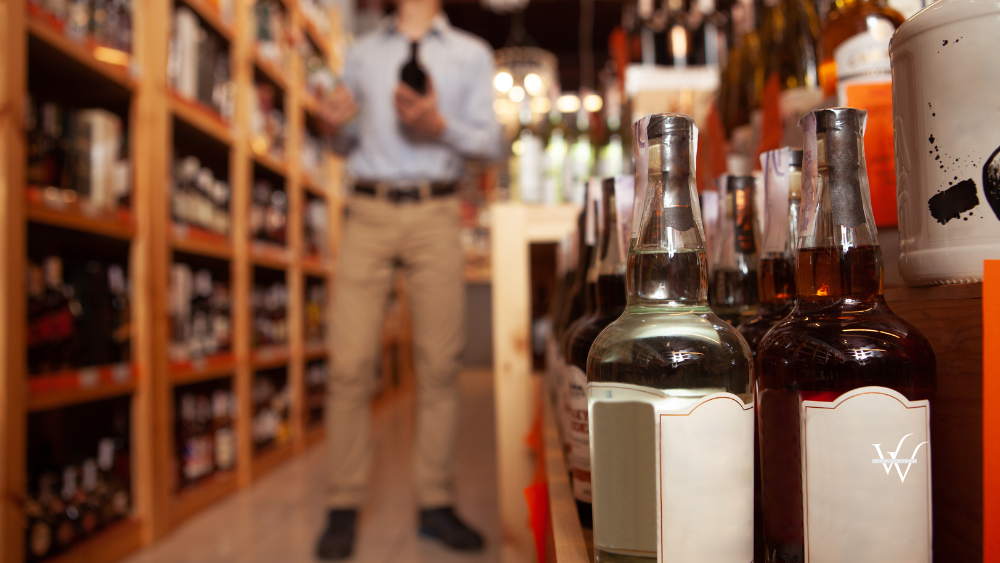 Handsome man shopping for alcohol at liquor store