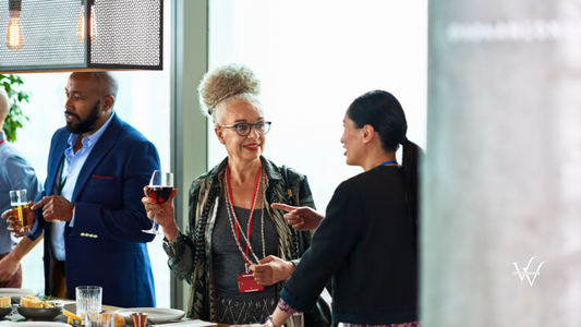 Senior woman drinking wine at business networking event