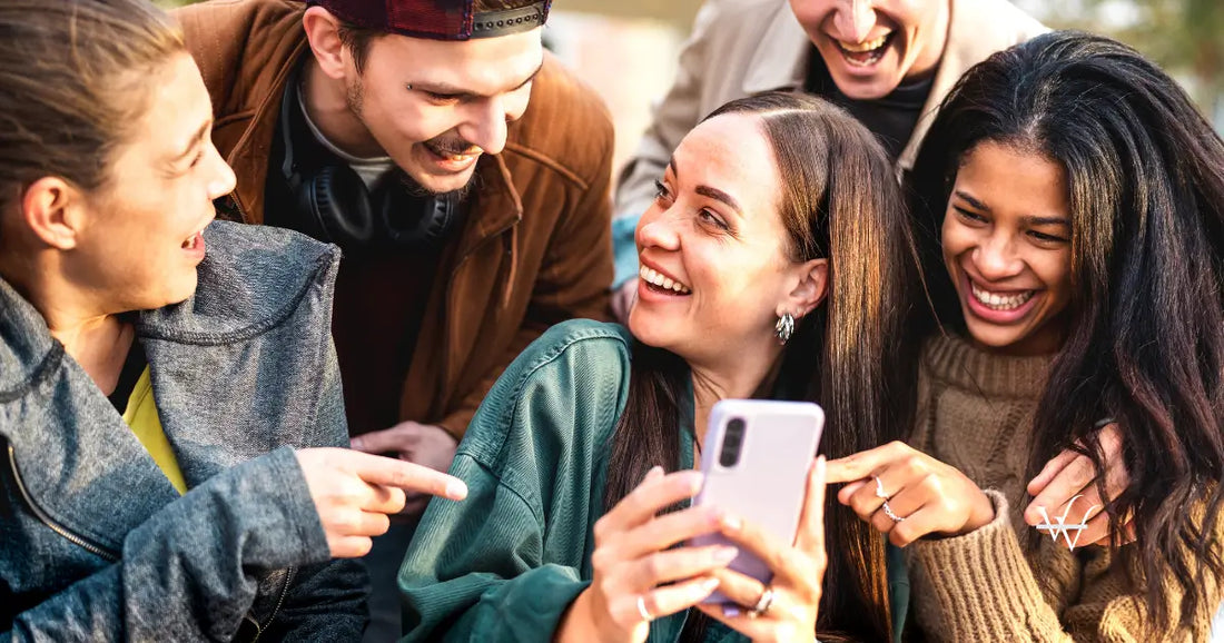 multicultural young people having fun with mobile phone at urban